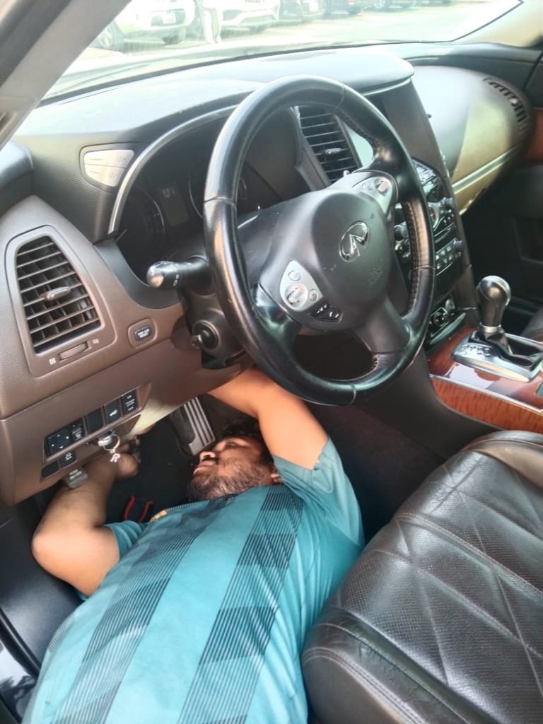 Mobile car mechanic working on car dashboard
